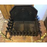 A cast iron and brass fire grate, with pierced sides and bottom and solid raised back with fleur-