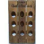 A folding wooden champagne rack with apertures for nine bottles, engraved ‘Champagne Charles