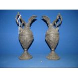 A pair of cast metal pitchers with raised motifs of grapes and vines, one spout slightly a/f.