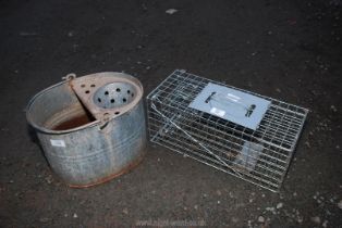 A vermin trap and galvanised mop bucket.