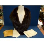 A dark brown fur wrap and a quantity of embroidered linen.