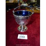 A pierced and embossed sugar Bowl on stand with delicate handle and blue glass liner,