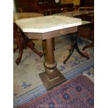 A contemporary eight sided polished marble/travertine stone topped Table standing on a tapering