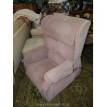 An electrically operated rise and fall Armchair upholstered in pink/beige fabric.