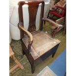 A Georgian Oak commode chair having a fret-worked back-splat,