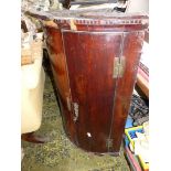 A Mahogany/Walnut cylinder fronted wall hanging Corner Cupboard having a dentil frieze and brass