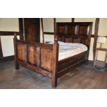 A heavy dark Oak double Bed having peg joined headboard with bevelled panels,