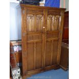 A contemporary Priory Oak style double Wardrobe having opposing doors with linen cold and fruiting