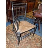 A stylish and appealing ebonised framed Elbow Chair having delicate turned details to the back and