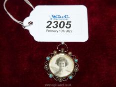 A 9ct gold pendant with sepia toned photos set with pearls and turquoise stones.