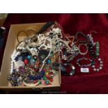 A quantity of costume jewellery including necklaces, bangles, shell necklaces, etc.