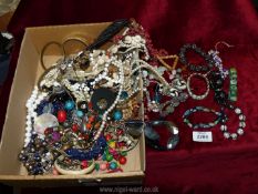 A quantity of costume jewellery including necklaces, bangles, shell necklaces, etc.