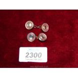 A pair of 18 ct gold backed Cufflinks set with a circle of small red stones on a dark Mother of