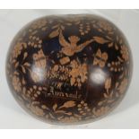 A Coco-de-mer or gourd carved with floral design and a bird carrying a letter,