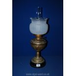 A brass oil lamp with scalloped edge shade, 23" tall.