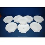 A set of eight white glass dishes in the form of clam shells.