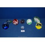 Eight glass paperweights to include a pebble paperweight signed M.