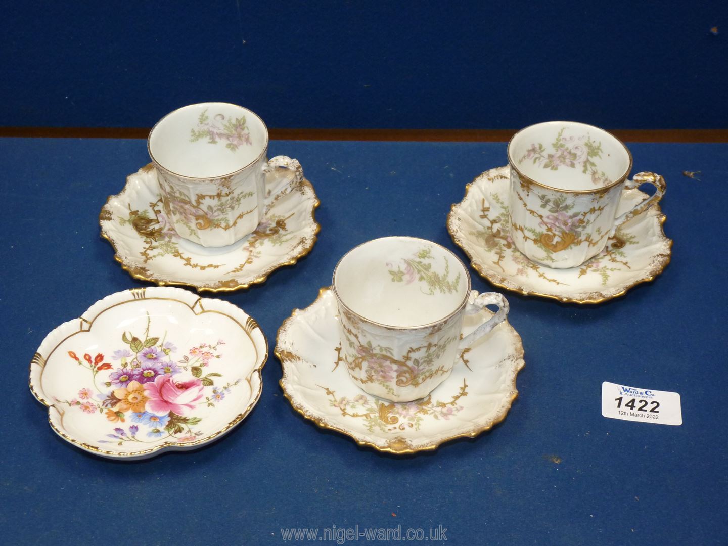 Three Limoges coffee cans and saucers with gold highlighted embossed detail and a Crown Derby