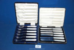 Two boxed sets of mother of pearl handled knives and forks.
