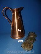 A copper jug, 27 cm tall and a set of three horse brasses.