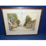 A framed and mounted Watercolour depicting a Village scene with houses and a church signed lower