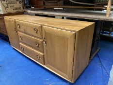 An Ercol Golden Dawn sideboard with central three drawers, flanked by cupboard either side,