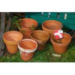 Six various sized terracotta pots.