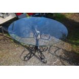 A wrought iron based table with glass top, 39" diameter.