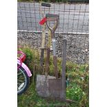 A miner's pick axe, spades and a fork.