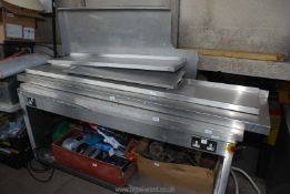 A stainless steel catering table with shelving. 69" long x 29" wide x 3' tall.