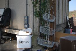 An enamel bread bin with a three tier hanging veg/fruit basket.