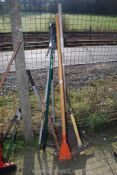 A long pole saw, long handled shovel, hole spade, pick axe, etc.