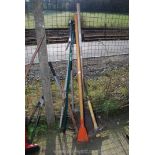 A long pole saw, long handled shovel, hole spade, pick axe, etc.