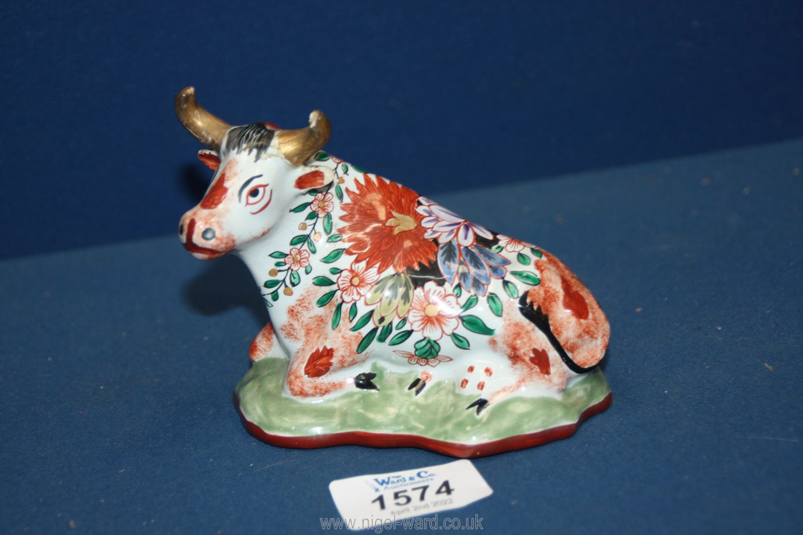 An antique Delft pottery figurine of a seated cow decorated in polychrome; (damage to one horn), - Image 2 of 4