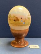 A painted Ostrich egg on wooden holder.