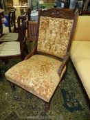 A dark Mahogany framed button backed Edwardian fireside Chair upholstered in stylised floral