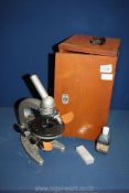 A wooden cased 'Omo' microscope, model M6P-1, with extra lenses and slides,