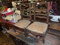 An pair of unusual low ladderback side Chairs with woven seagrass seats and shaped front legs.