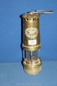 A brass Miner's Lamp, marked Thomas & Williams, Aberdare, 11 1/2'' tall.