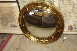A brass framed concave porthole Mirror, 16 1/2'' diameter.