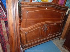 A Walnut and other woods double Bedstead having carved foliage and floral decoration,