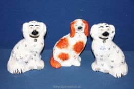 A pair of white Beswick Spaniels, plus one other, a/f, 8'' tall.