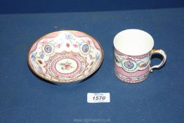 A Sevres coffee can and saucer, painted with floral garlands against a mottled salmon pink ground,