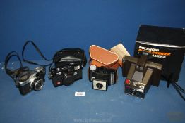 Four cameras including Super Swinger Polaroid Land , Olympus Trip 35, Coronet and Halina MW35E.