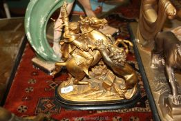 A gilt coloured metal figure of an Arab on horseback being attacked by a lion.