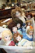 Eight porcelain headed dolls in period dress, some on stands,