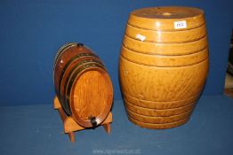 A wooden whisky barrel on stand with tap and a treacle glazed barrel stamped C & J.