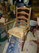 A rustic Ash and other woods ladder-back open armed Elbow chair having a woven seagrass seat (one