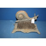 A cast iron snail Boot Scraper, some brushes a/f, 10" wide x 6" deep x 6 1/2" tall.