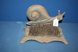 A cast iron snail Boot Scraper, some brushes a/f, 10" wide x 6" deep x 6 1/2" tall.